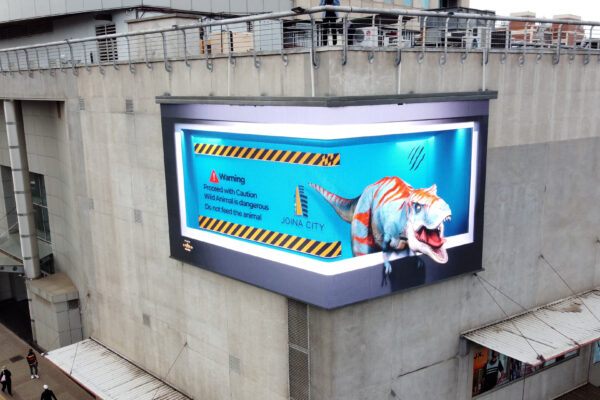 3D anamorphic billboard animation for Joina City, Harare, featuring a hyper-realistic dinosaur created by Kakic Business. Uses forced perspective to create a "breaking the screen" effect for high-impact street marketing.
