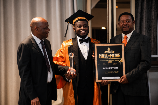 Kudakwashe Maxwell receiving the Excellence in Digital Media and Visual Storytelling Award., holding the 2026 National Excellence Hall of Fame plaque